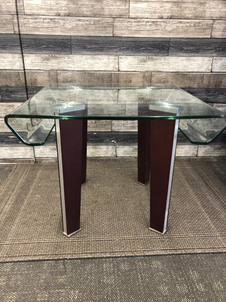 MODERN GLASS END TABLE W/CURVED TOP & WOOD LEGS.