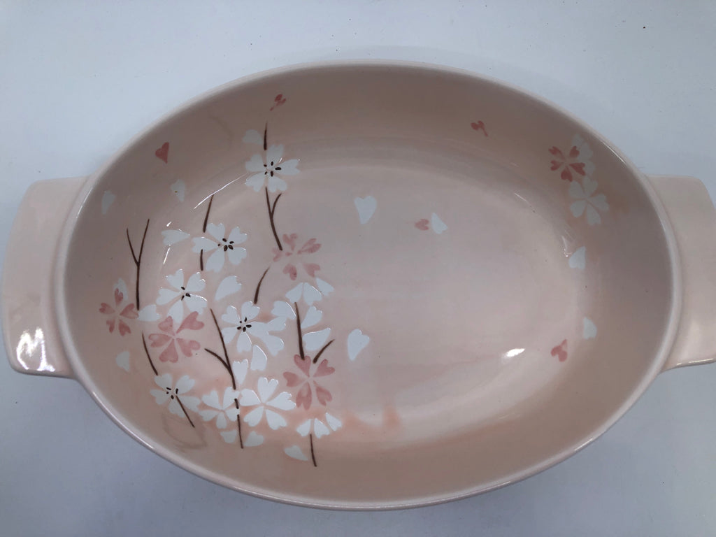 LIGHT PINK OVAL BAKING DISH W WHITE FLORAL AND HANDLES.