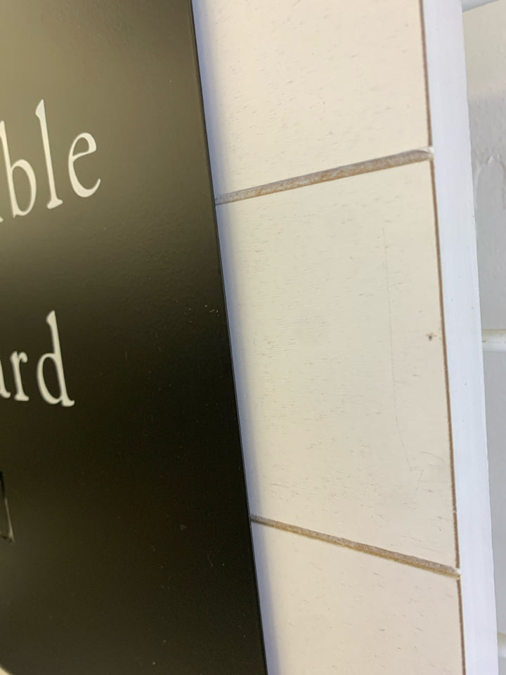 STAY HUMBLE WORK HARD KIND METAL CUT-OUT SIGN ON WHITE WOOD.