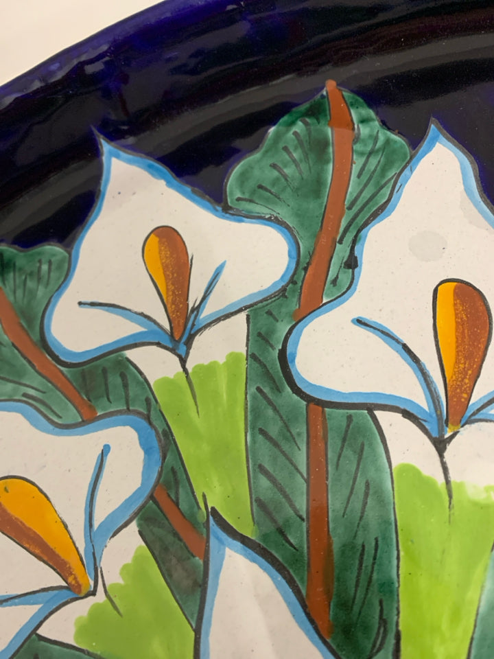 LARGE OVAL TERRA COTTA PLATTER W/ WHITE FLOWERS DARL BLUE BACKGROUND.