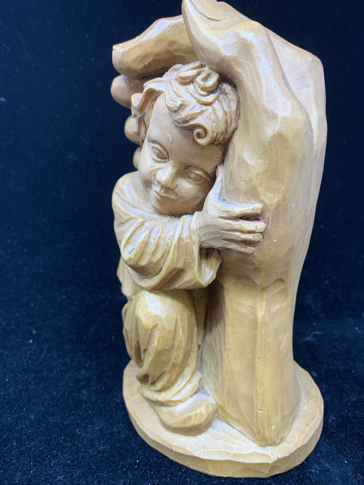 RESIN CARVED HAND HOLDING BABY.
