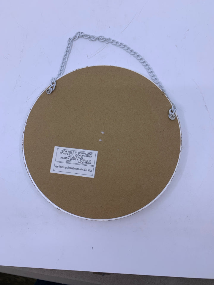 CIRCLE WHITE WASHED FRAME W/ PAINTED WHITE FLOWERS.