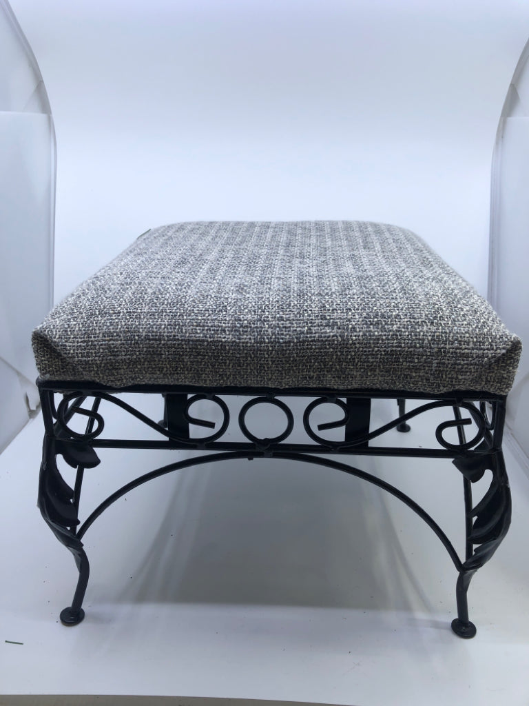 GREY FABRIC FOOTSTOOL W/BLACK IRON SCROLL LEGS.