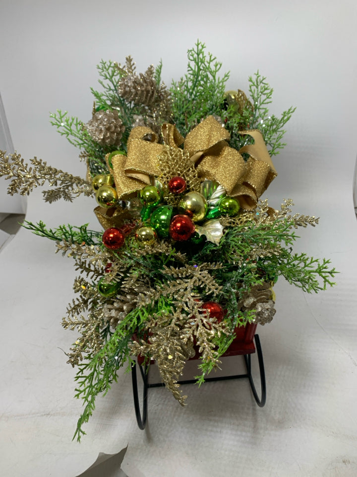 RED SLEIGH W/ HOLIDAY FLORAL ARRANGEMENT.