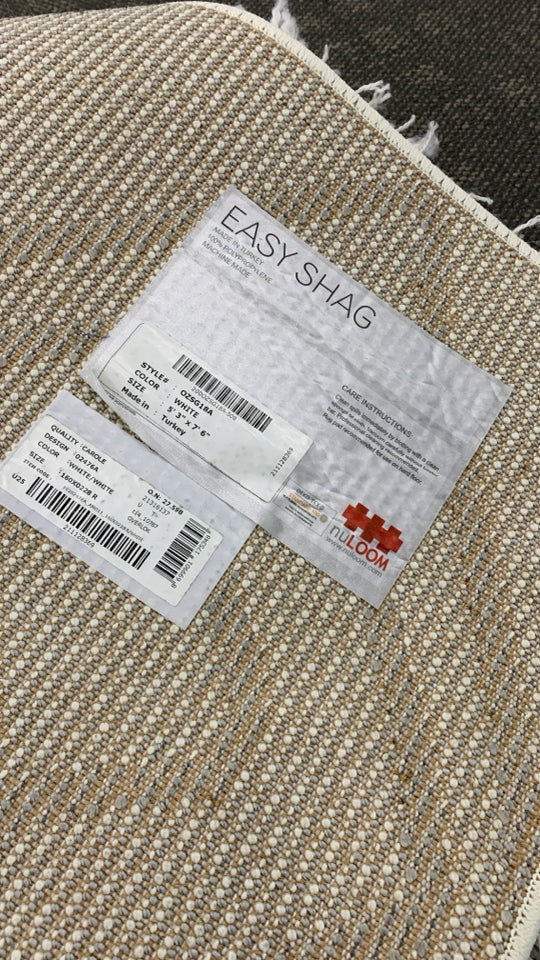 WHITE SHAG RUG W/GREY DIAMOND PATTERN.