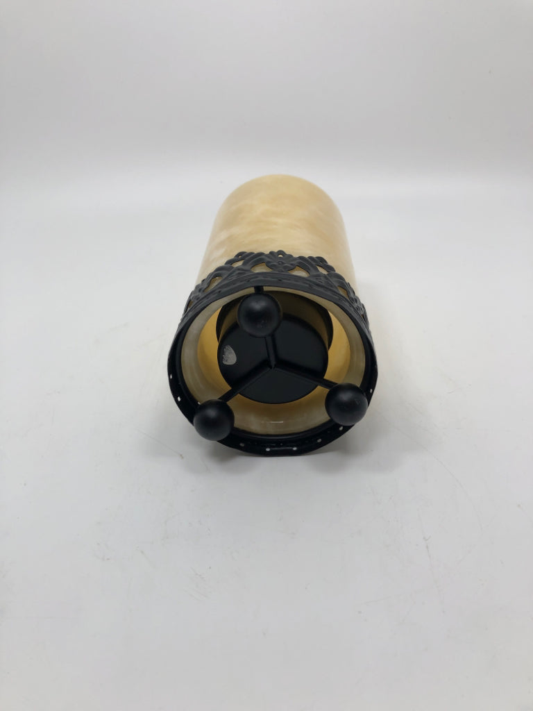 CREAM RESIN TEA LIGHT HOLDER ON BLACK METAL BASE.