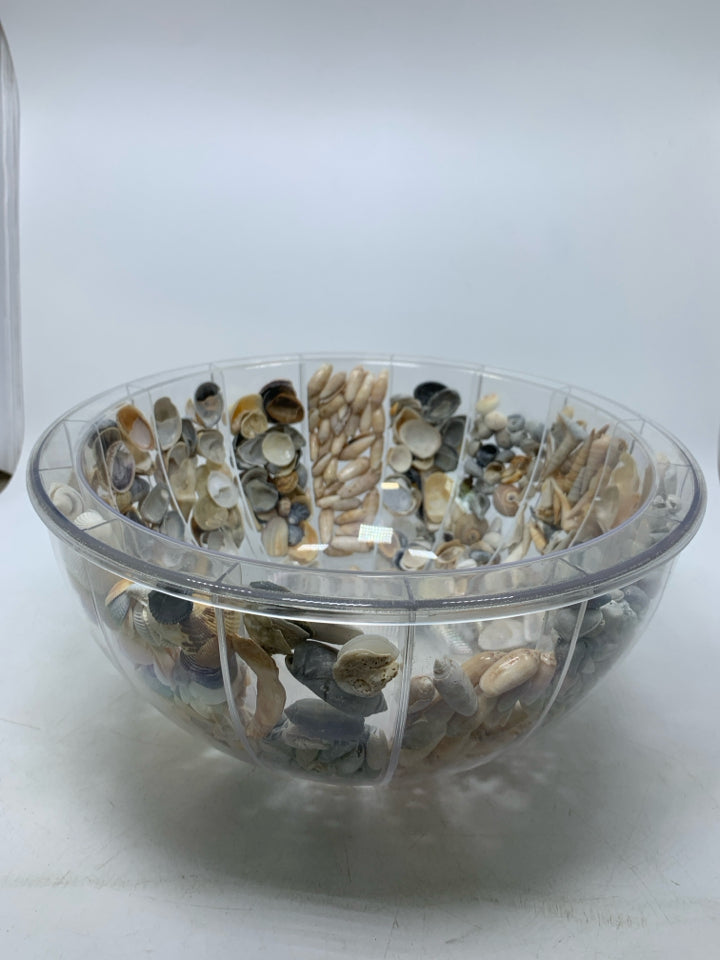 CLEAR PLASTIC BOWL FILLED W/ SHELLS INSIDE.