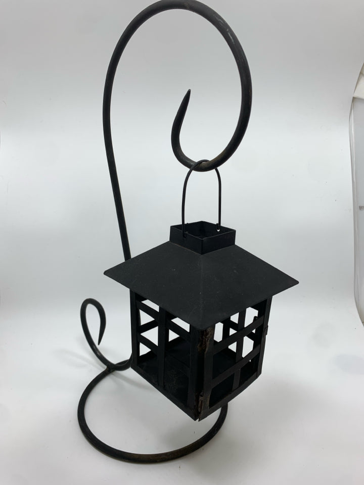 BLACK METAL LANTERN ON SCROLL STAND.