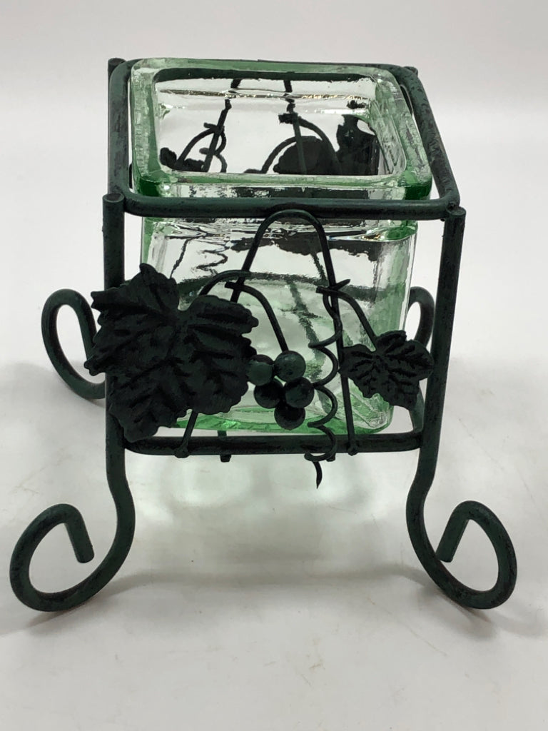 GREEN GLASS VOTIVE HOLDER IN GREEN METAL STAND.
