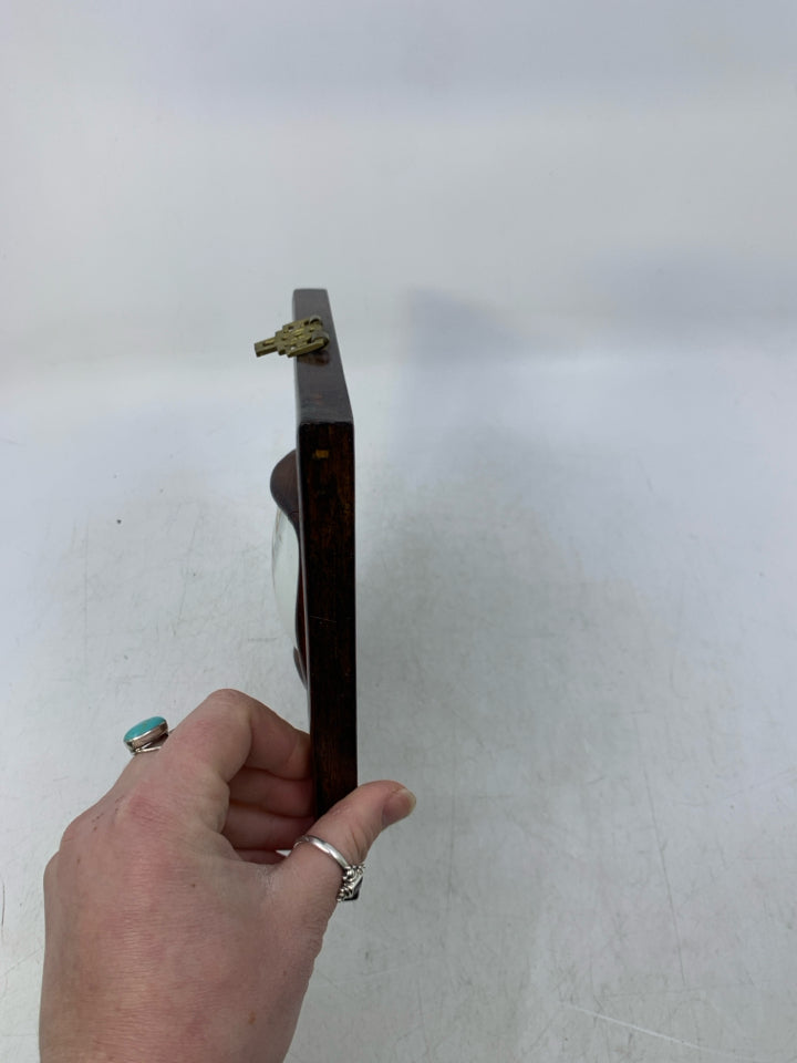 WOOD WALL HANGING W/ 2 MEN LOOKING AT EACHOTHER POTTERY PIECE.