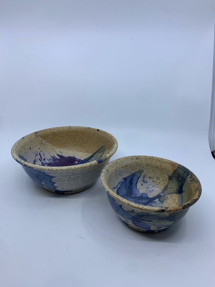 2 NESTING TAN AND BLUE POTTERY BOWLS.