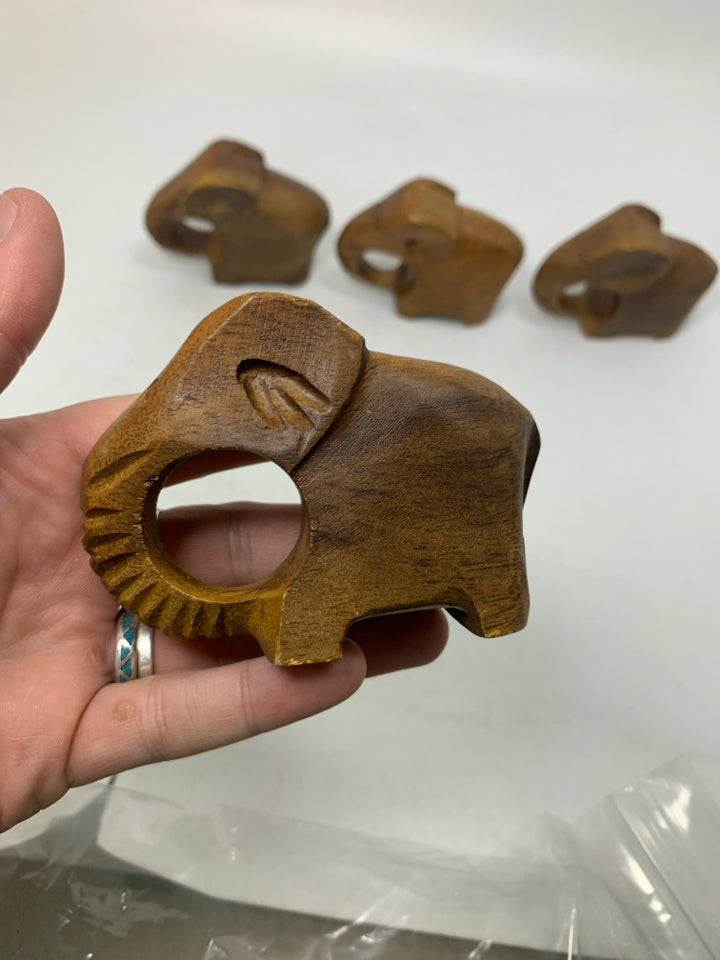 4 WOOD CARVED ELEPHANT NAPKIN RINGS IN BAG.