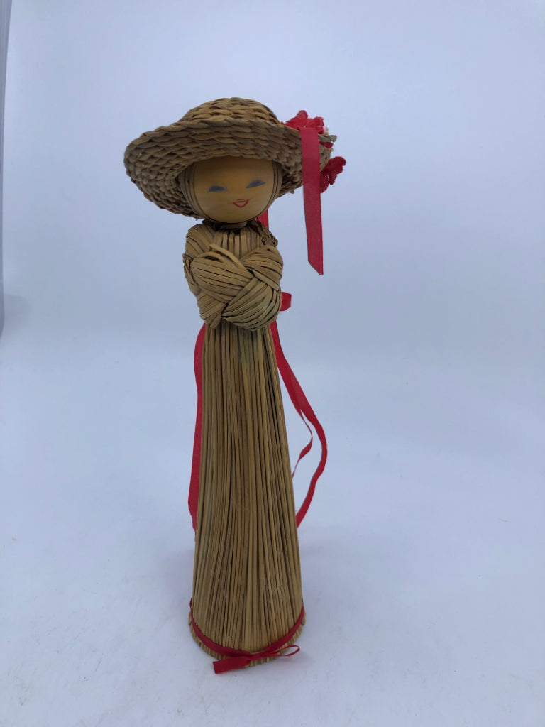 STRAW LADY W/HAT AND RED RIBBON.