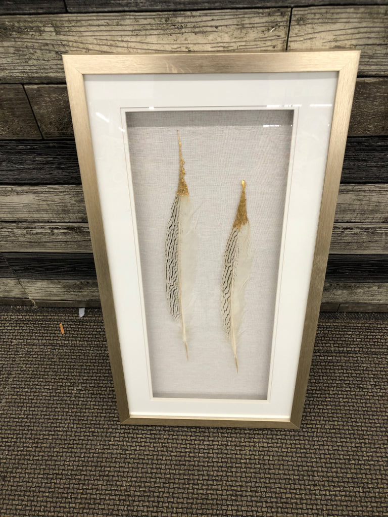 2 FEATHERS W GOLD TIPS SHADOW BOX IN GOLD FRAME.