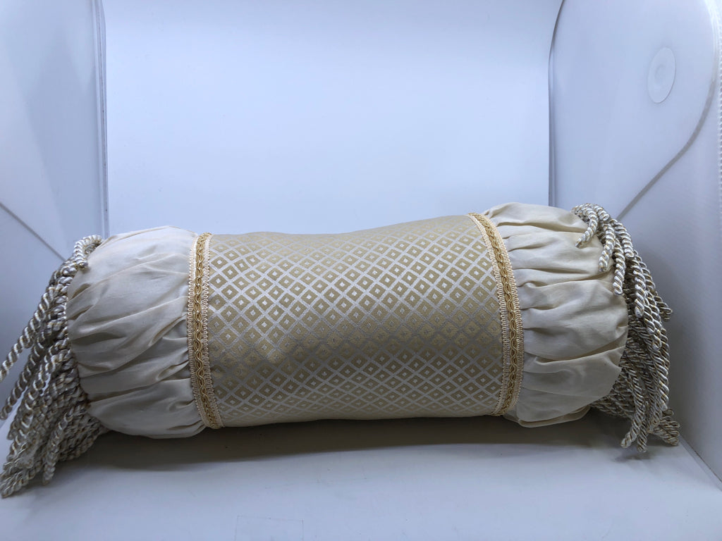 CREAM CYLINDER PILLOW WITH TASSELS.