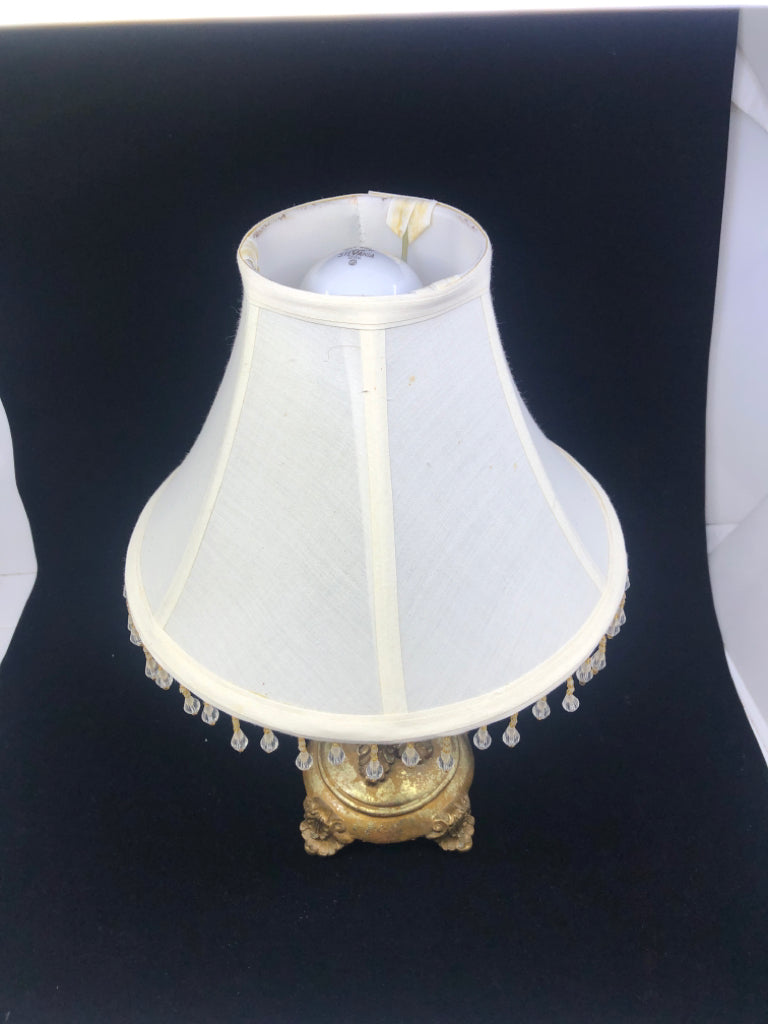 GOLD EMBOSSED FOOTED SCROLL DETAIL BASE LAMP W/ CREAM BEADED SHADE.