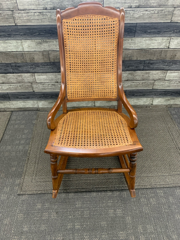 VINTAGE DARK BROWN CANE SEAT ROCKER.