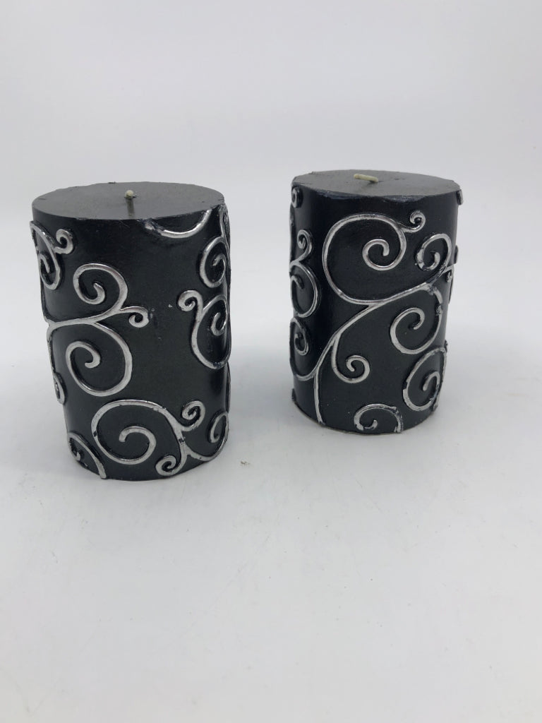 2 BLACK SCROLL PILLAR CANDLES.