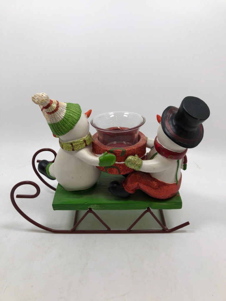 SNOWMEN ON SLEIGH HOLDING VOTIVE HOLDER.