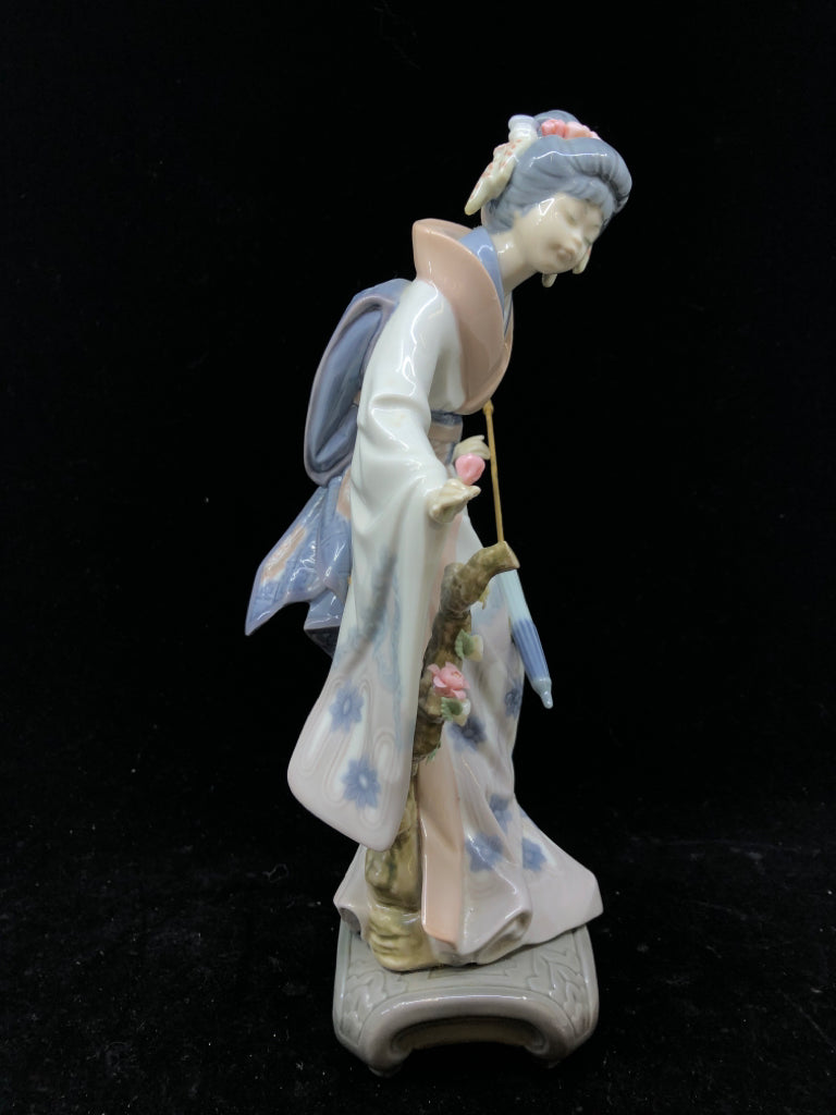 LLADRO WOMAN HOLDING UMBRELLA BENDING OVER.