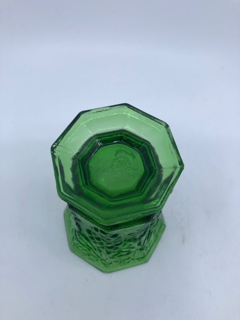 GREEN GLASS FOOTED  HEXAGON VASE W/ EMBOSSED GRAPES.