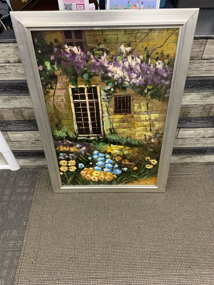 LARGE FLOWER GARDEN IN FRONT OF BUILDING PRINT IN SILVER FRAME.