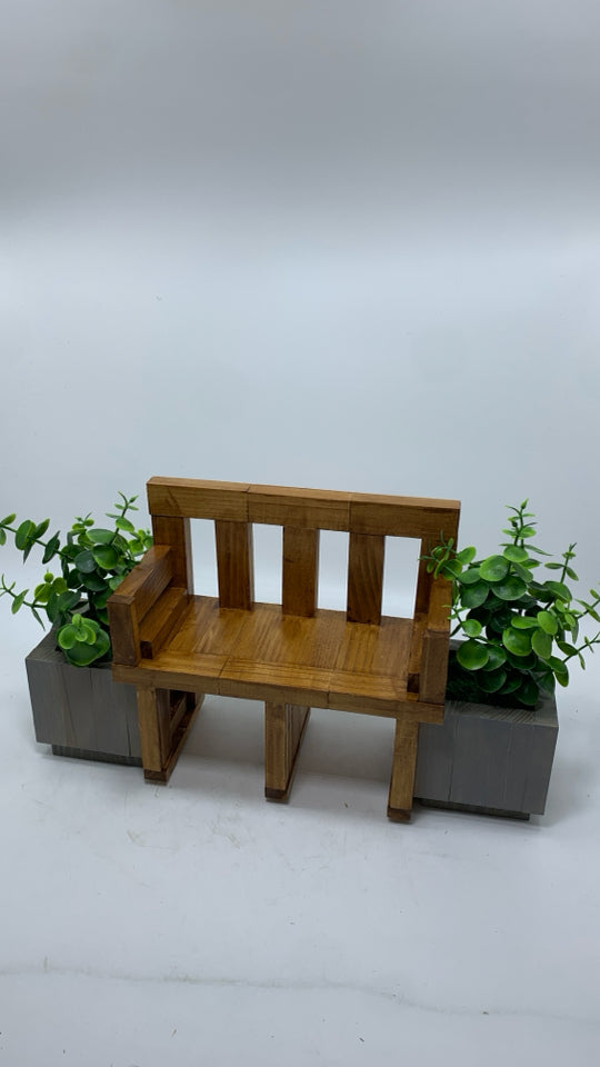 WOOD DOLL BENCH W/FAUX LEAVES IN GREY POTS.