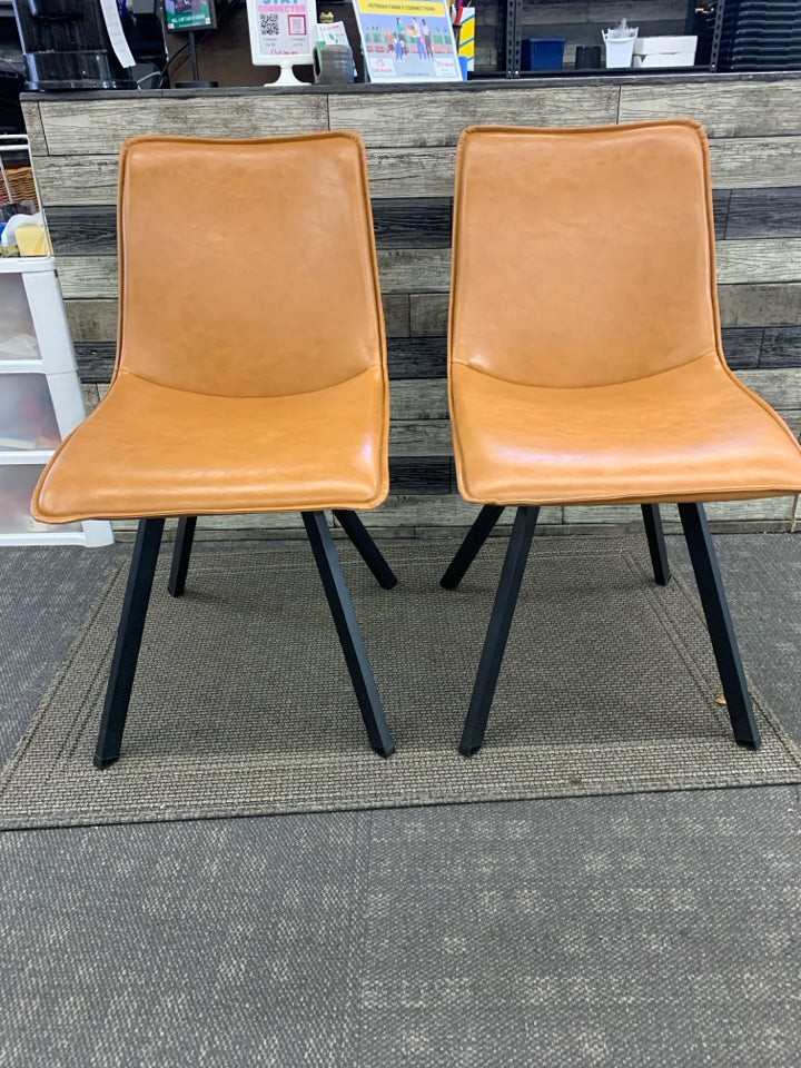 2 CARMEL COLORED FAUX LEATHER ACCENT CHAIRS W/ BLACK METAL LEGS.