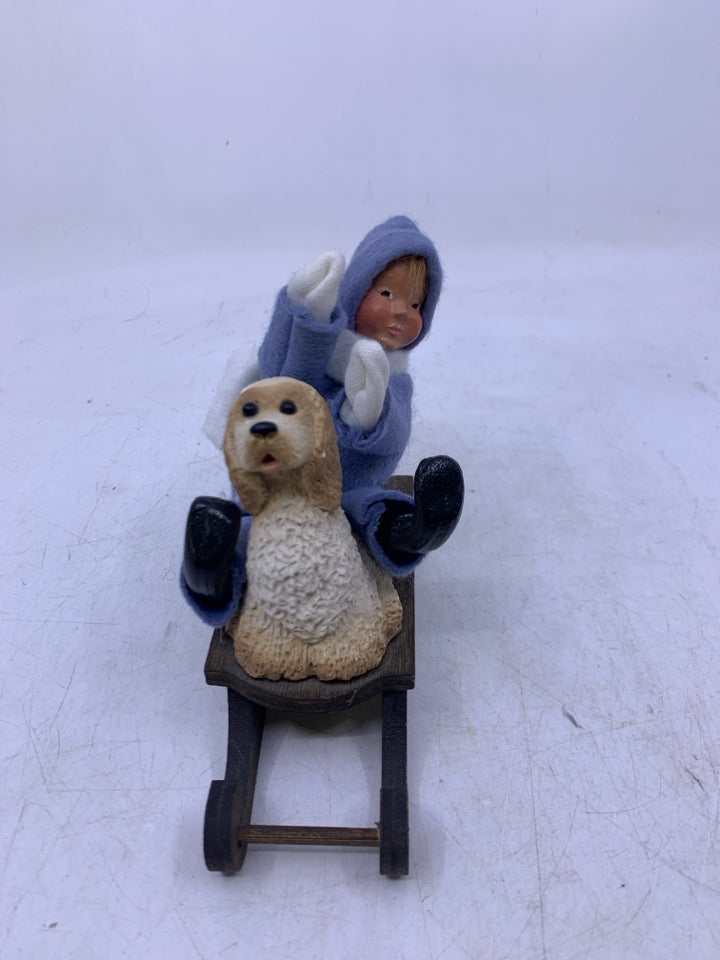 KID IN LIGHT BLUE SUIT ON SLED W/ DOG BYERS' CHOICE 1991.