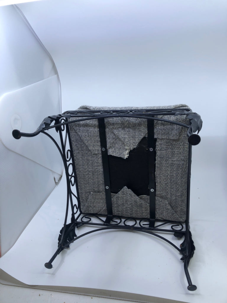 GREY FABRIC FOOTSTOOL W/BLACK IRON SCROLL LEGS.