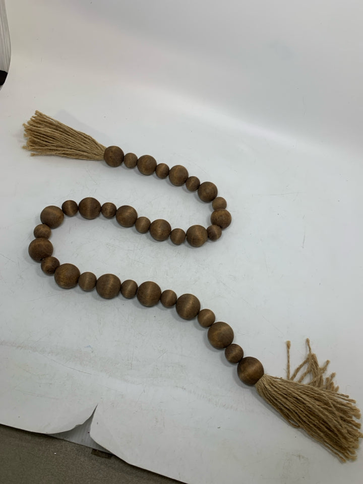 WOOD BEADED GARLAND W/ TWINE TASSELS.