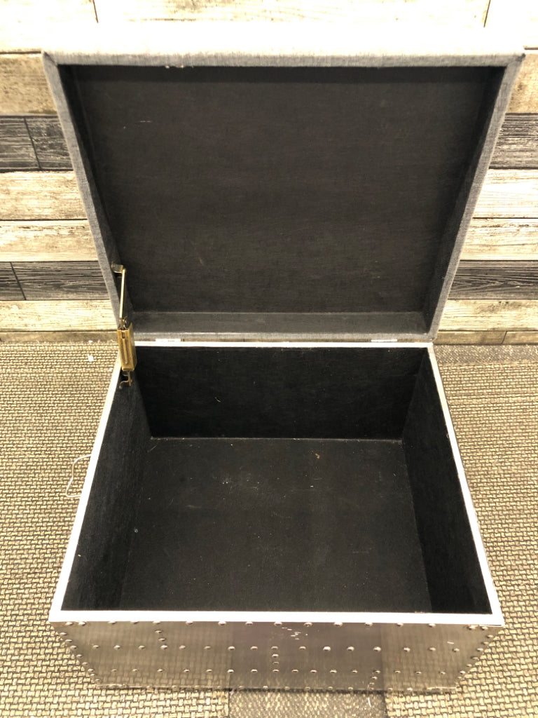 SMALL GREY STUDDED OTTOMAN W METAL HANDLES AND STORAGE.