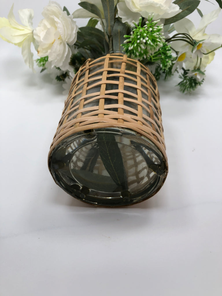 WHITE FLORALS IN COVERED WEAVE GLASS VASE.
