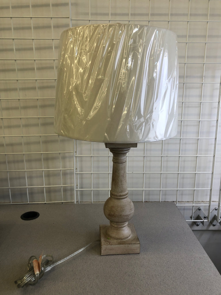 GRAY DISTRESSED LAMP WITH WHITE LAMP SHADE.