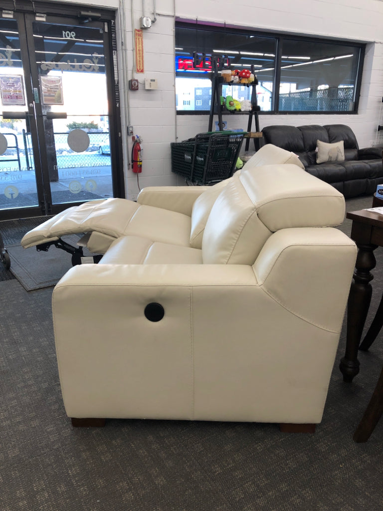 WHITE FAUX LEATHER RECLINING LOVE SEAT.