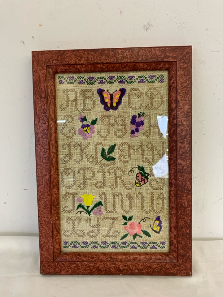 ABC'S NEEDLEPOINT SAMPLER IN RED FRAME WALL HANGING.