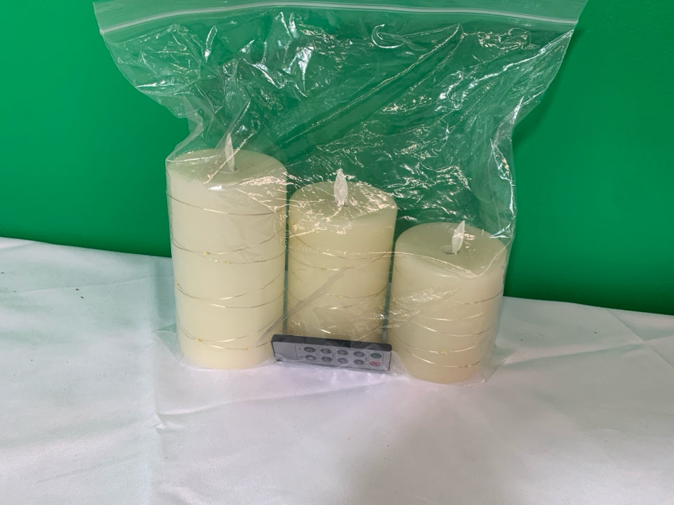 3 WHITE WITH GOLD BATTERY OPERATED CANDLES WITH REMOTE.