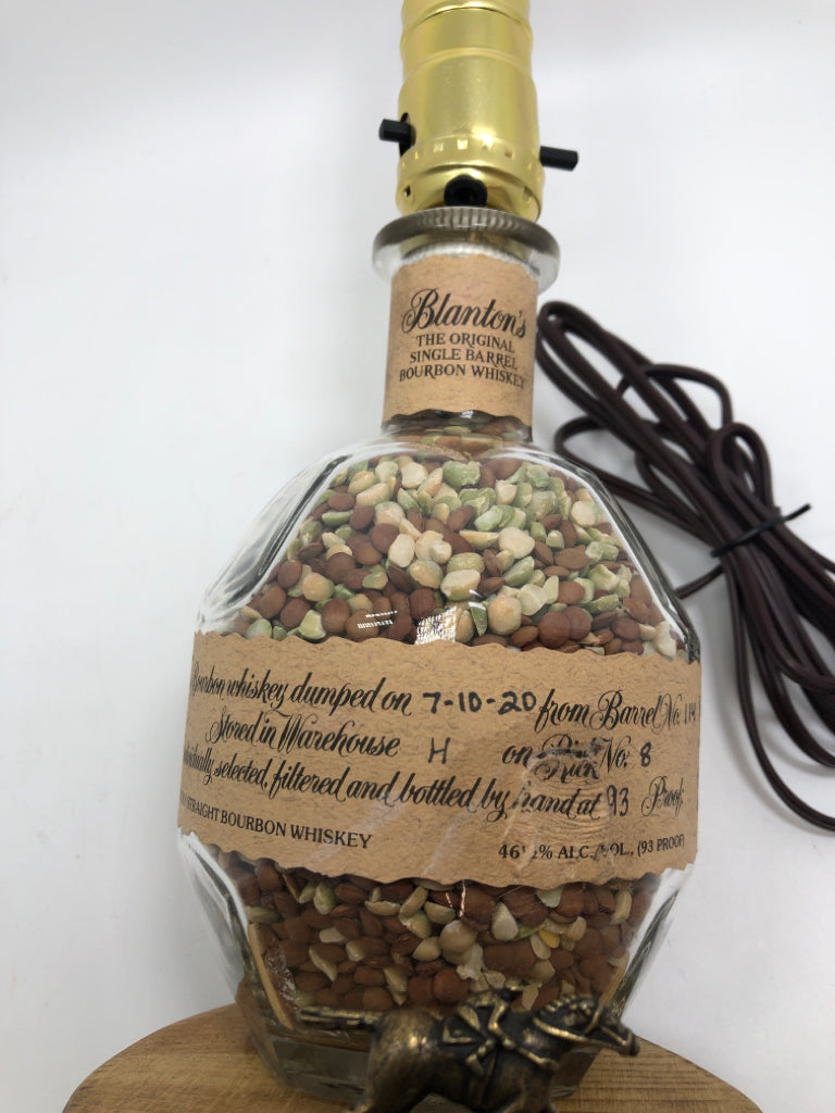 BOURBON BOTTLE LAMP W/TAN SHADE.