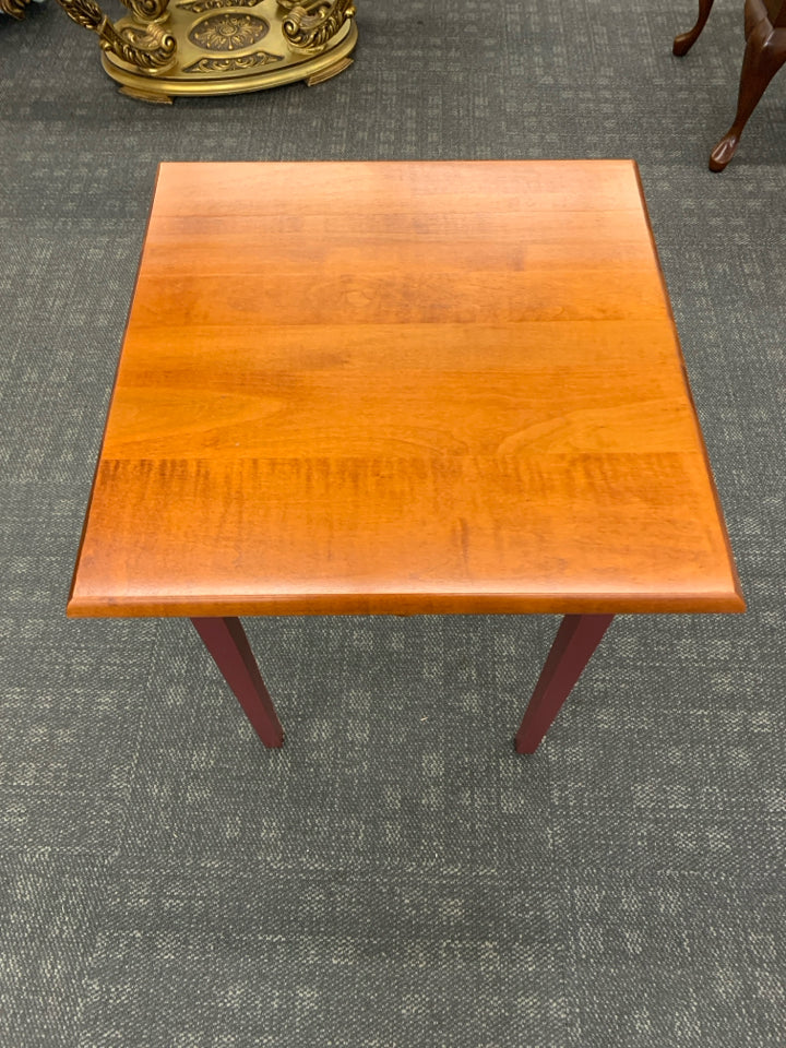 CHERRY WOOD SIDE TABLE W/DRAWER AND RED PAINTED LEGS.