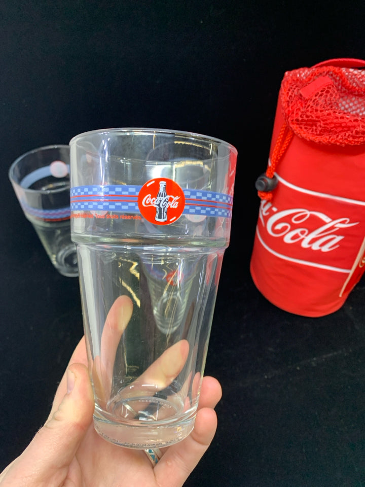 4 COCA-COLA THEMED STACKABLE GLASSES IN CARRYING SLEEVE.