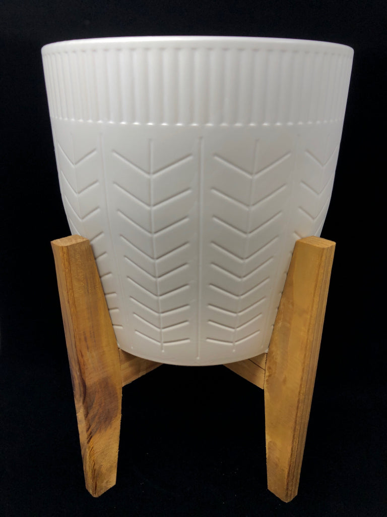CERAMIC PLANTER W/LINES ON WOOD LEGS.