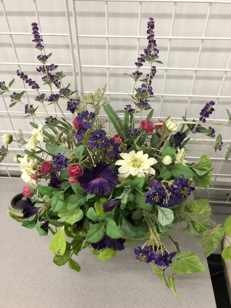 FAUX PURPLE FLOWERS IN GALVANIZED TIN WALL POCKET.