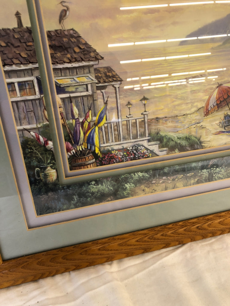 PEOPLE SITTING UNDER UMBRELLA BY THE BEACH WALL ART IN WOOD FRAME.