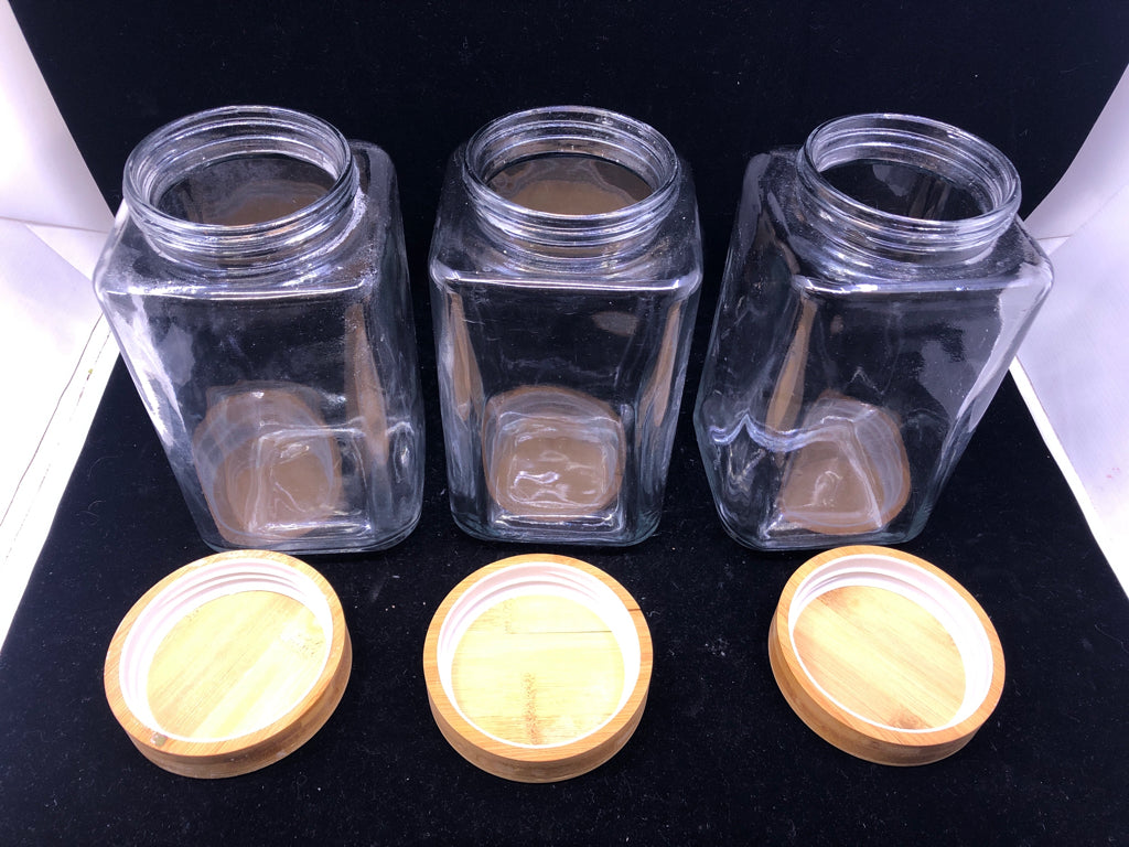 3 GLASS SQUARE CANISTERS W/ WOOD TOPS.