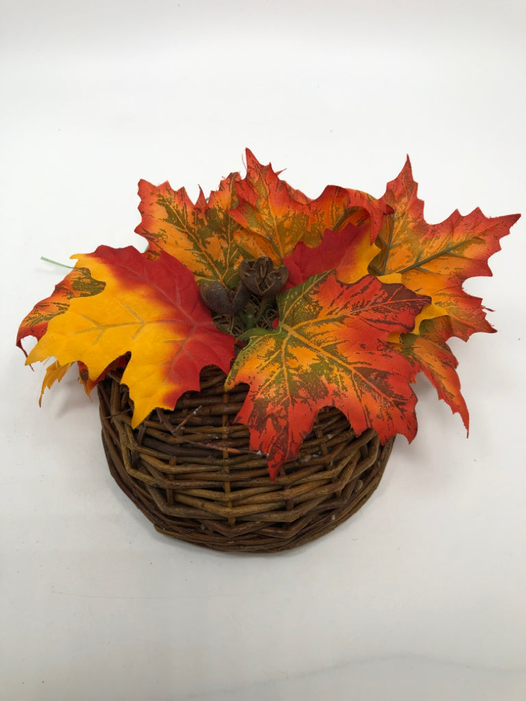 ORANGE LEAVES IN BROWN WICKER HANGING BASKET.