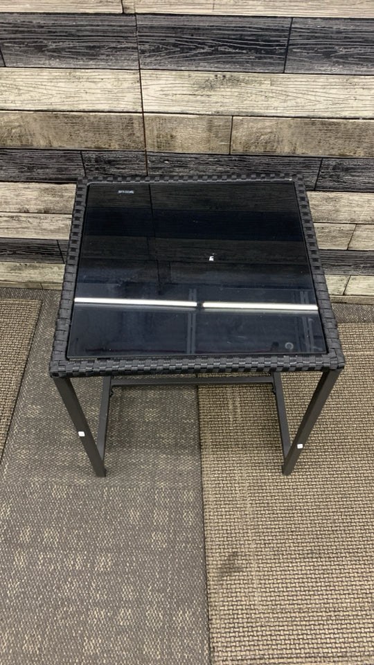 BLACK METAL OUTDOOR SIDE TABLE W/WOVEN EDGE AND TEMPERED GLASS TOP.