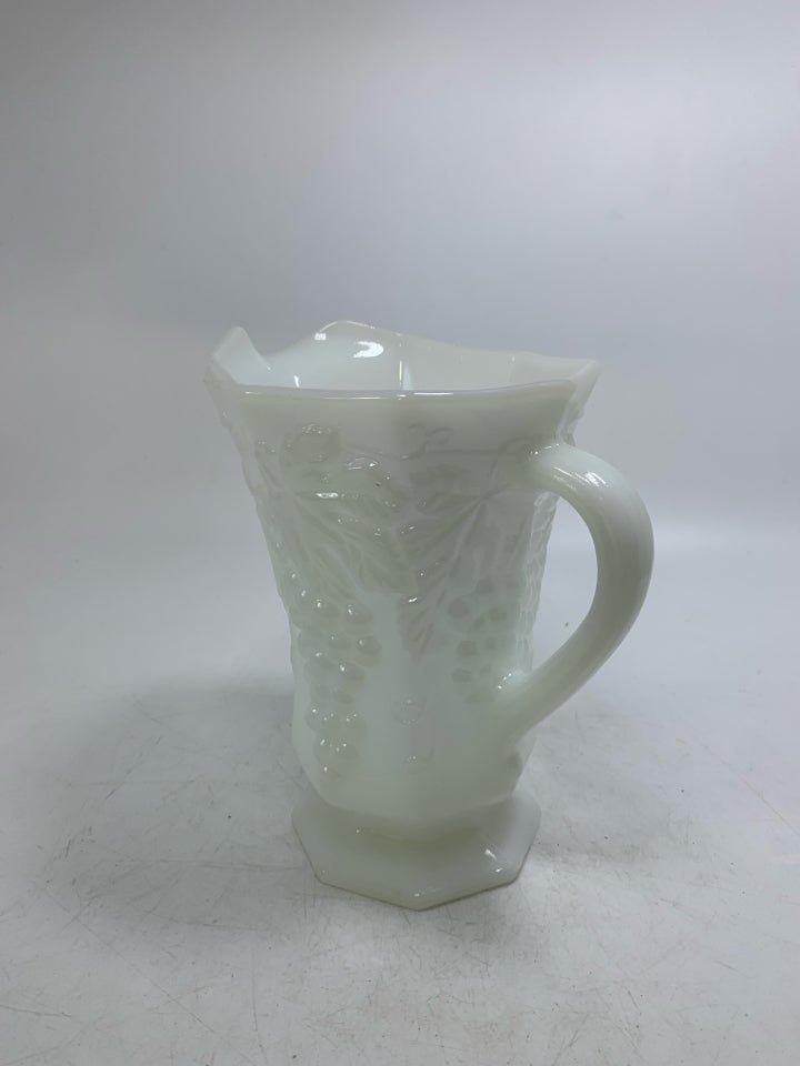 FOOTED MILK GLASS PITCHER W/ EMBOSSED GRAPES.