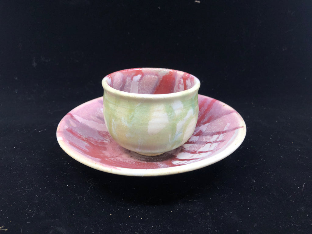 RED/PINK POTTERY CUP AND RAISED EDGE SAUCER.