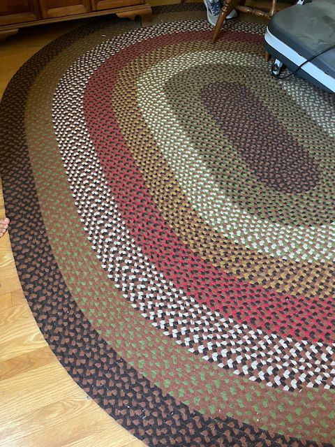 BROWN, RED, GREEN OVAL BRAIDED RUG.