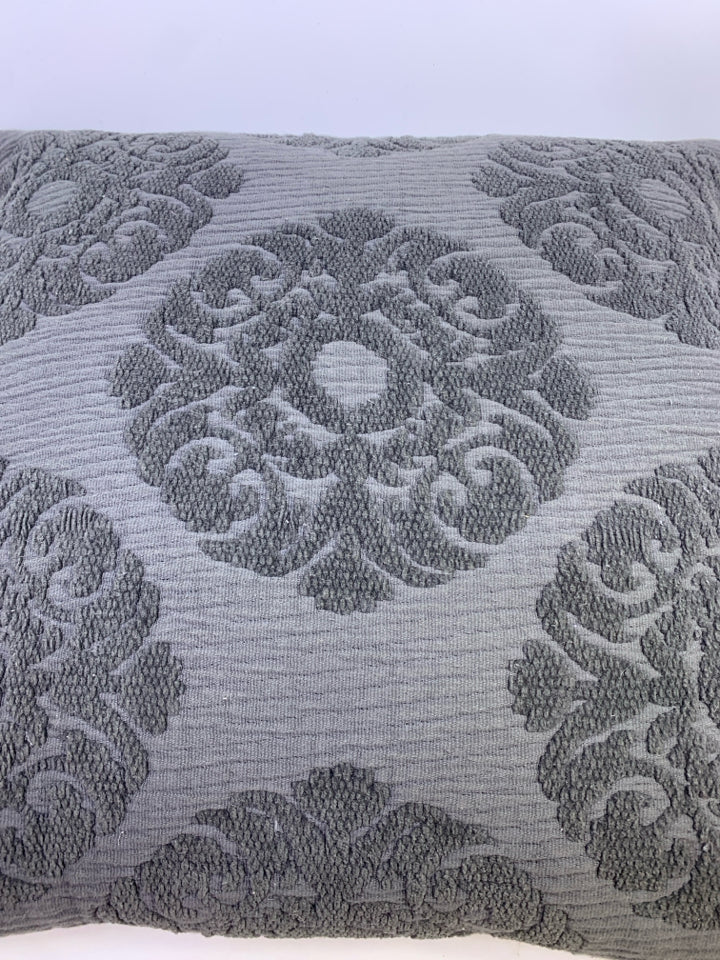 DARK GREY PILLOW W/ EMBOSSED MEDALLION DESIGN.